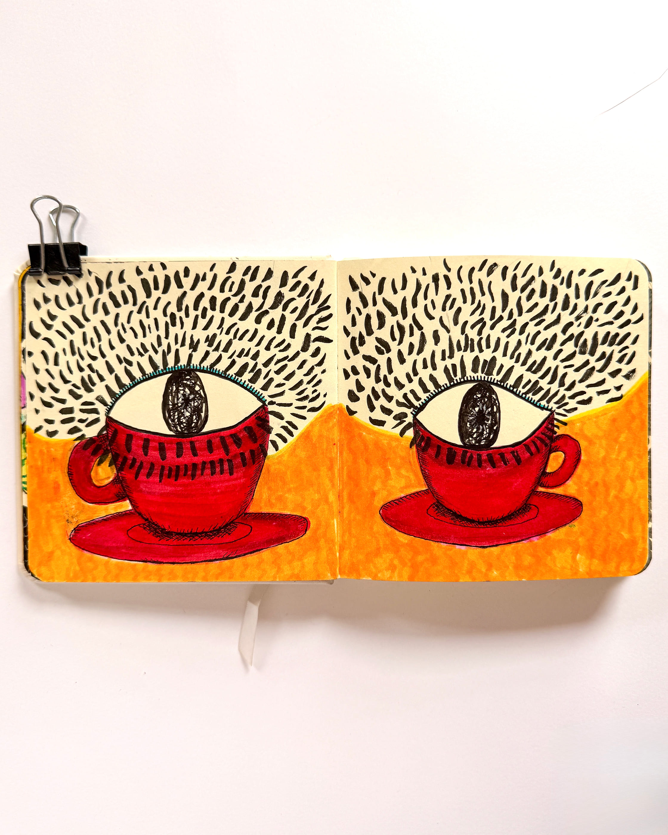 Two red teacups on saucers, each holding a single wide-open eye where the tea should be, against a flat orange ground with a dense field of black ink dashes above. Drawn across a sketchbook spread held open with a binder clip.